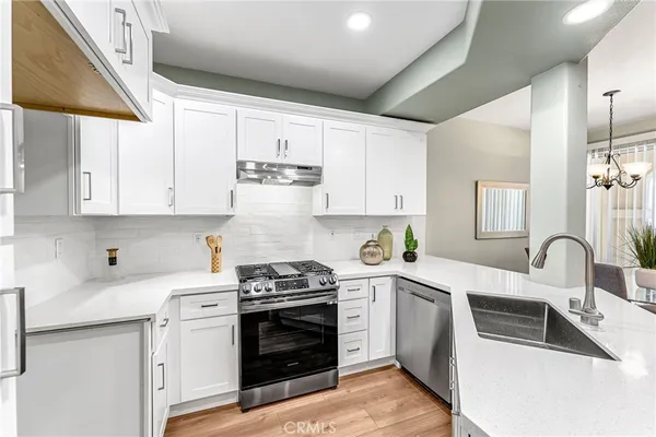 a kitchen with white cabinets a sink and appliances