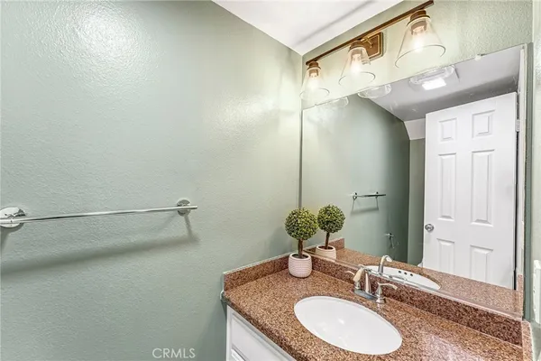 a bathroom with a granite countertop sink and a mirror
