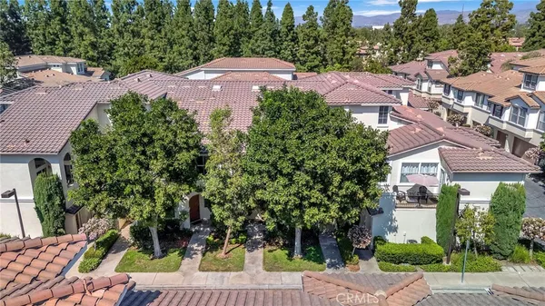 an aerial view of a house with garden space and trees all around