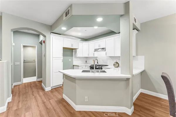 a kitchen with kitchen island a sink stainless steel appliances and cabinets