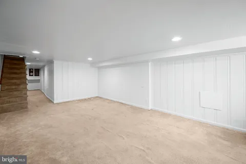 a large bedroom with a bed and wooden floor