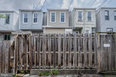 a view of a house with a wooden fence