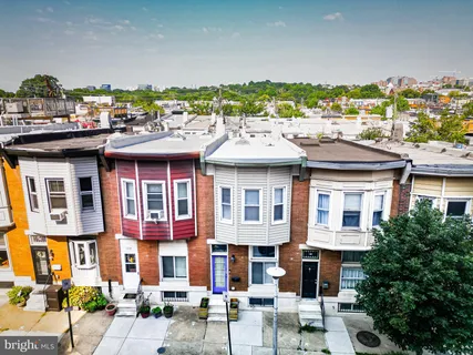 a view of a building with a garden and seating area