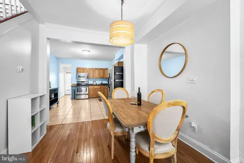 a view of a dining room with furniture a potted plant and wooden floor