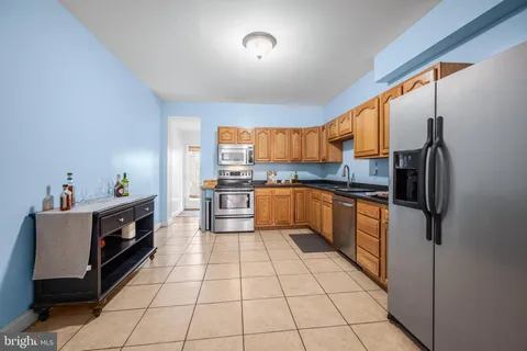 a kitchen with granite countertop a refrigerator and a stove top oven