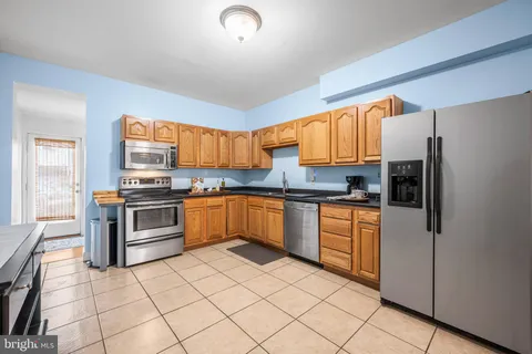 a kitchen with stainless steel appliances granite countertop a stove top oven a sink and a refrigerator