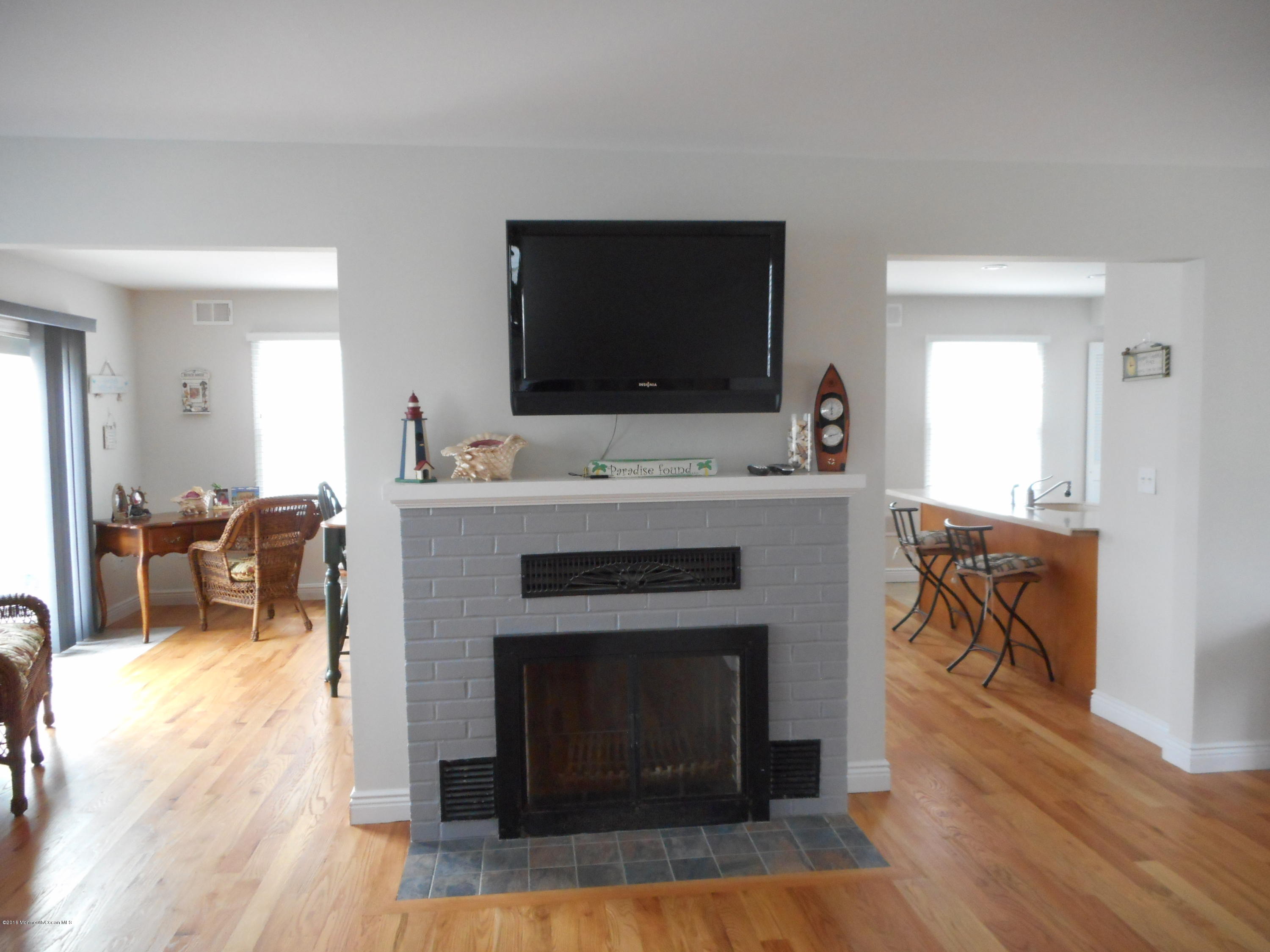 712 Drum Point Road Brick, NJ 08723 - Photo 11 of 23 a living room with furniture a flat screen tv and a fireplace