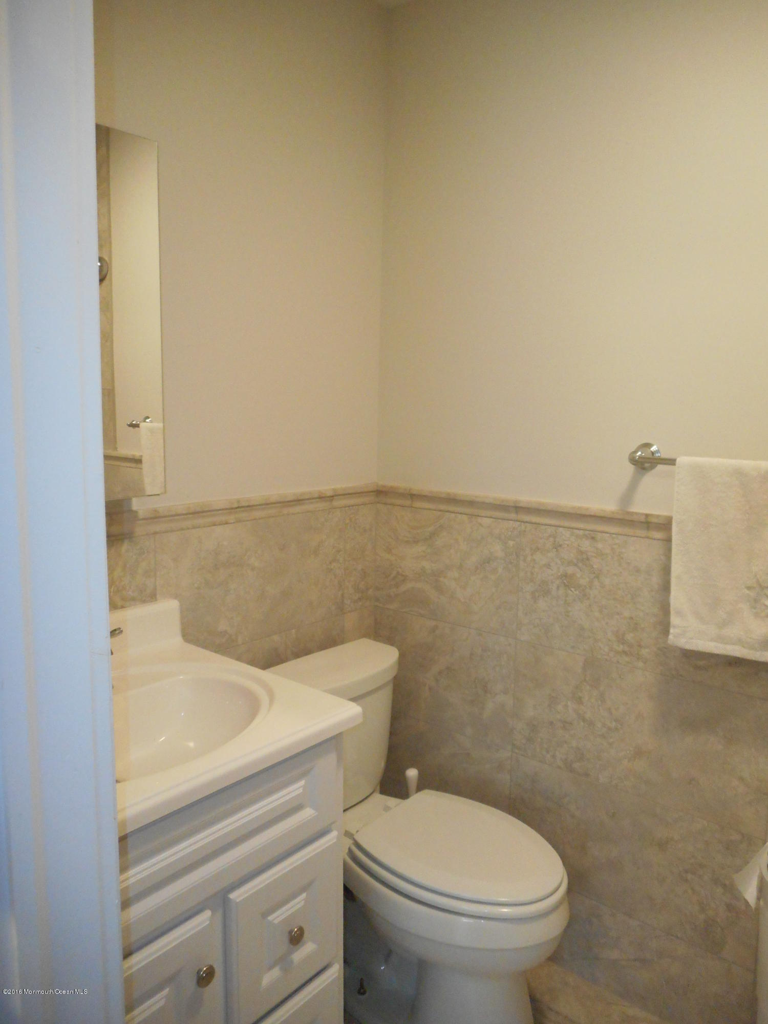 712 Drum Point Road Brick, NJ 08723 - Photo 22 of 23 a bathroom with a toilet a sink and mirror