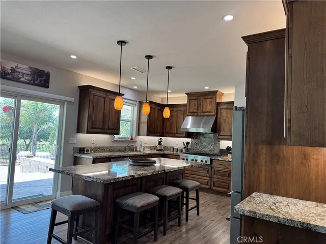 a kitchen with stainless steel appliances granite countertop a sink a stove and a refrigerator