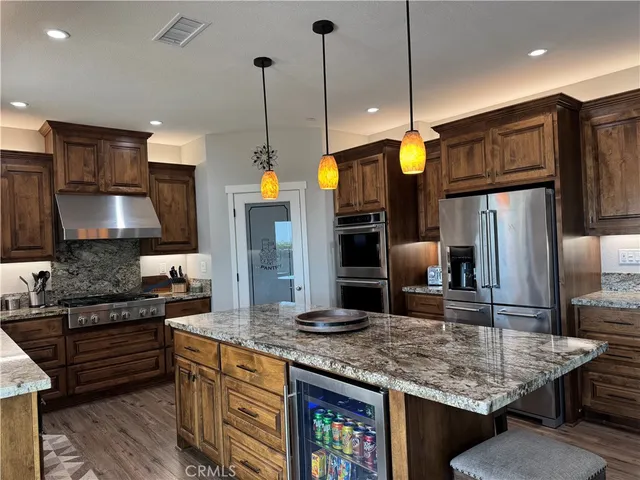 a kitchen with granite countertop a stove top oven and cabinets