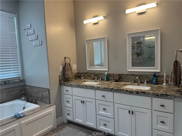 a bathroom with a granite countertop toilet and sink