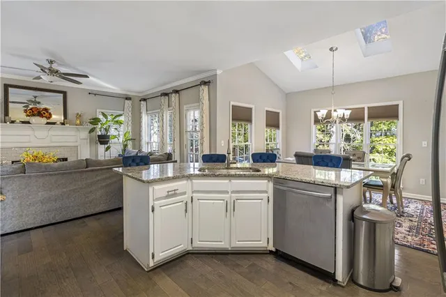 a kitchen with cabinets stainless steel appliances a sink and wooden floor