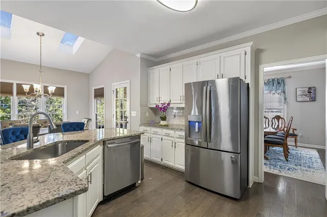 a view of a dining room with furniture a rug and wooden floor
