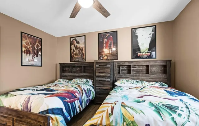 a bedroom with two beds and a large mirror on the dresser