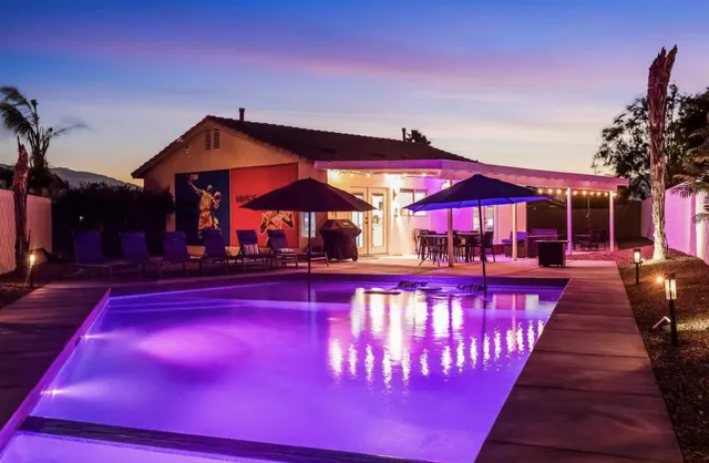 a view of swimming pool with tables and chairs under an umbrella