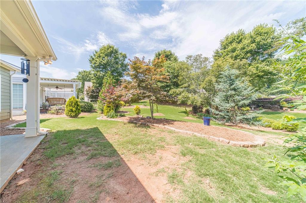 6260 Brookside Lane Hoschton, GA 30548 - Photo 11 of 59 a view of a yard with plants and a trees