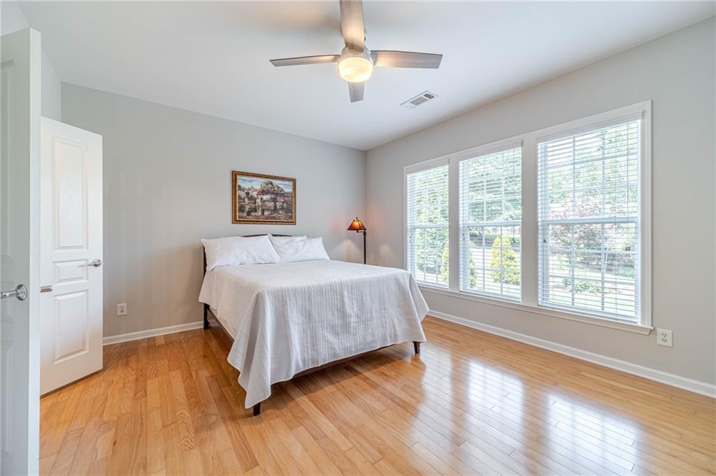 6260 Brookside Lane Hoschton, GA 30548 - Photo 24 of 59 a bedroom with a bed and a chandelier