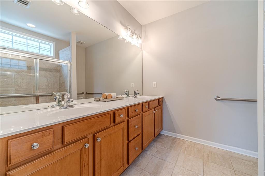 6260 Brookside Lane Hoschton, GA 30548 - Photo 28 of 59 a bathroom with a double vanity sink and a mirror