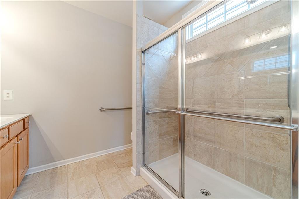 6260 Brookside Lane Hoschton, GA 30548 - Photo 29 of 59 a bathroom with a glass shower door