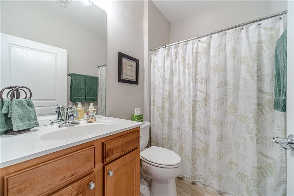 6260 Brookside Lane Hoschton, GA 30548 - Photo 34 of 59 a bathroom with a sink a toilet and shower curtain