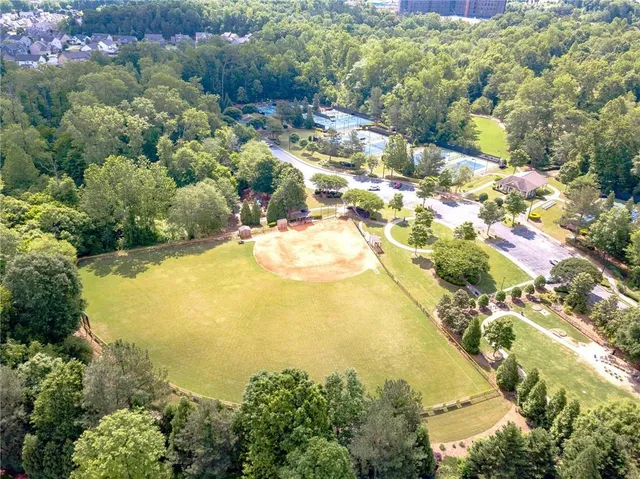 an aerial view of residential house with outdoor space and trees all around