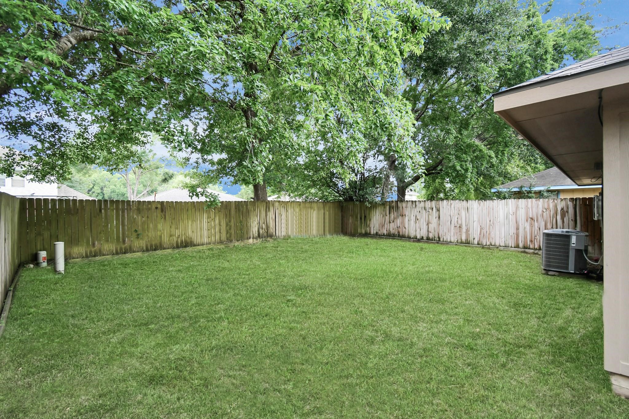 23507 Tree House Lane Spring, TX 77373 - Photo 14 of 17 a view of a backyard with large trees and wooden fence