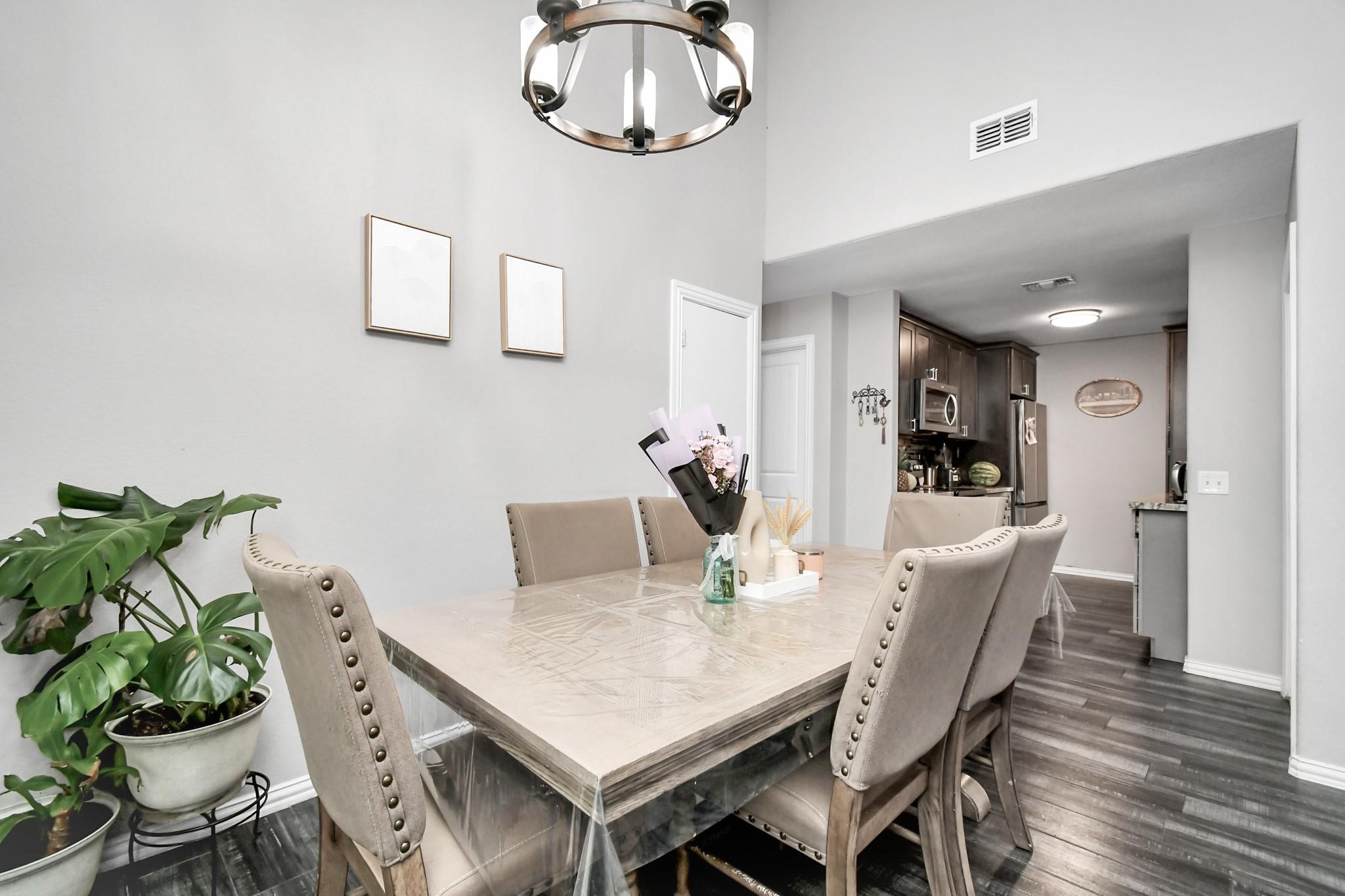23507 Tree House Lane Spring, TX 77373 - Photo 4 of 17 a view of a dining room with furniture a potted plant and wooden floor