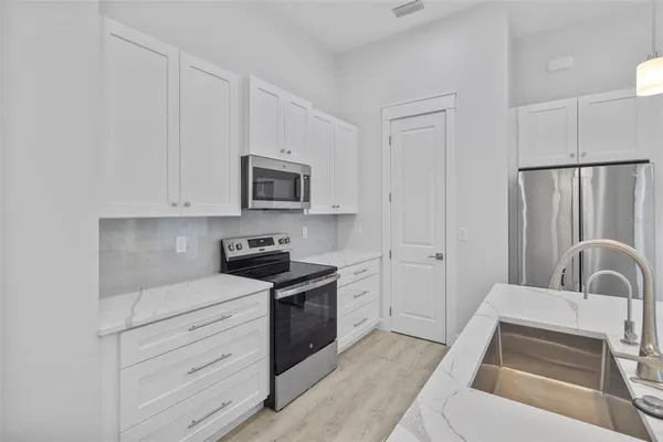 a kitchen with white cabinets and stainless steel appliances