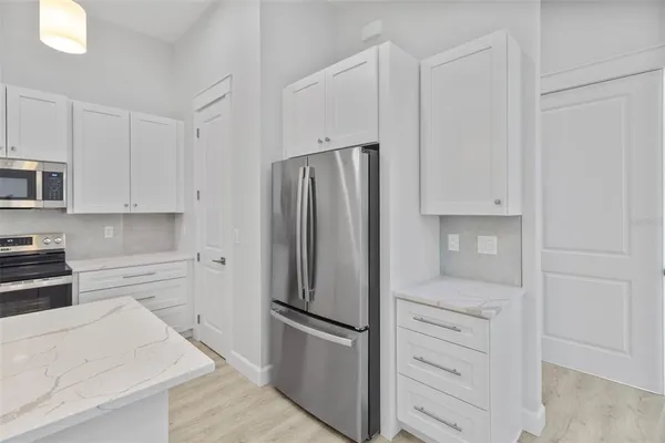 a kitchen with white cabinets and stainless steel appliances