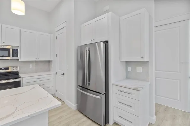 a kitchen with white cabinets and stainless steel appliances