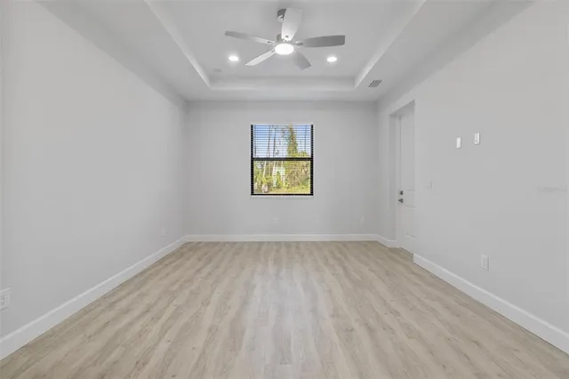 an empty room with a window and ceiling fan