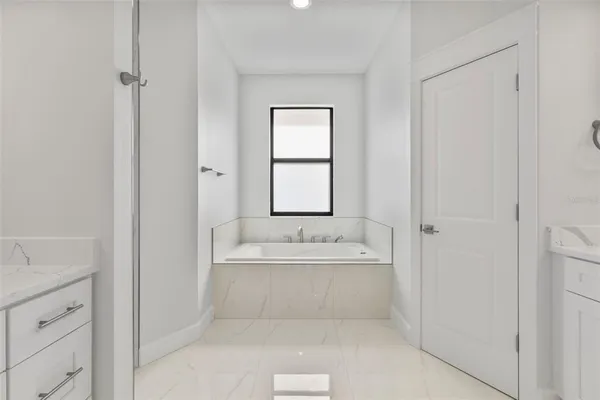a spacious bathroom with a bathtub sink and mirror