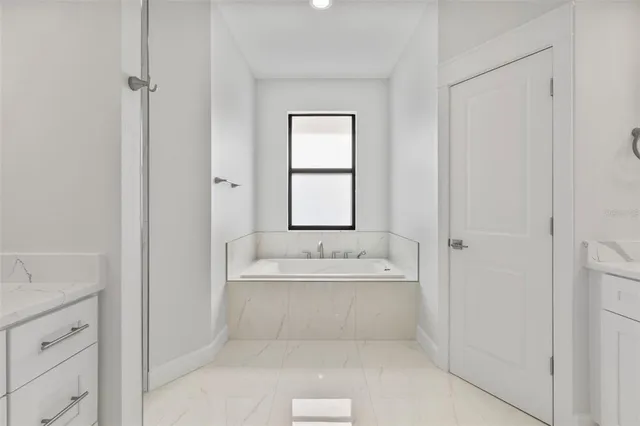 a spacious bathroom with a bathtub sink and mirror