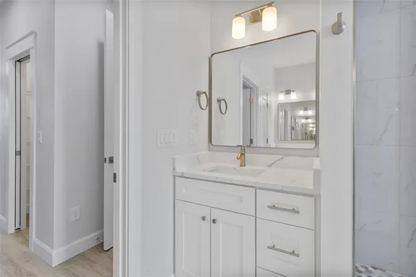 a bathroom with a granite countertop sink vanity and mirror