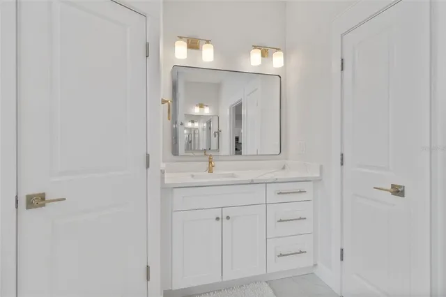 a bathroom with a granite countertop sink and a mirror