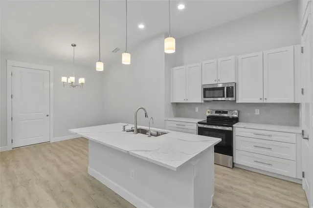 a kitchen with appliances a sink and cabinets