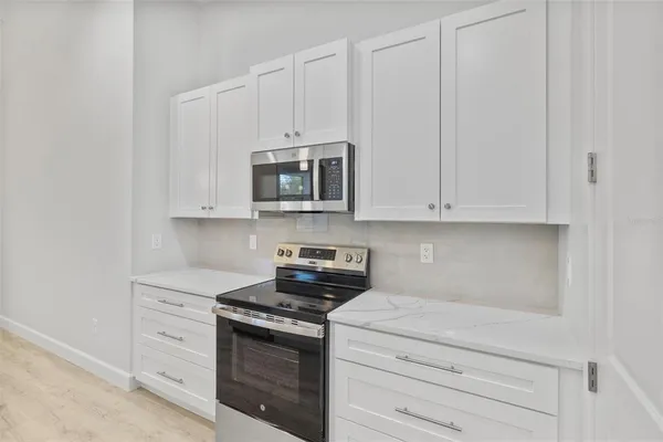 a kitchen with white cabinets and stainless steel appliances