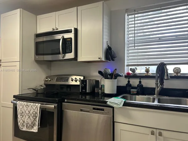 a kitchen with stainless steel appliances granite countertop a sink stove and microwave