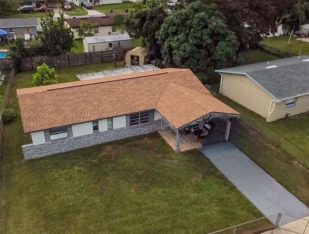 an aerial view of a house with swimming pool and a yard