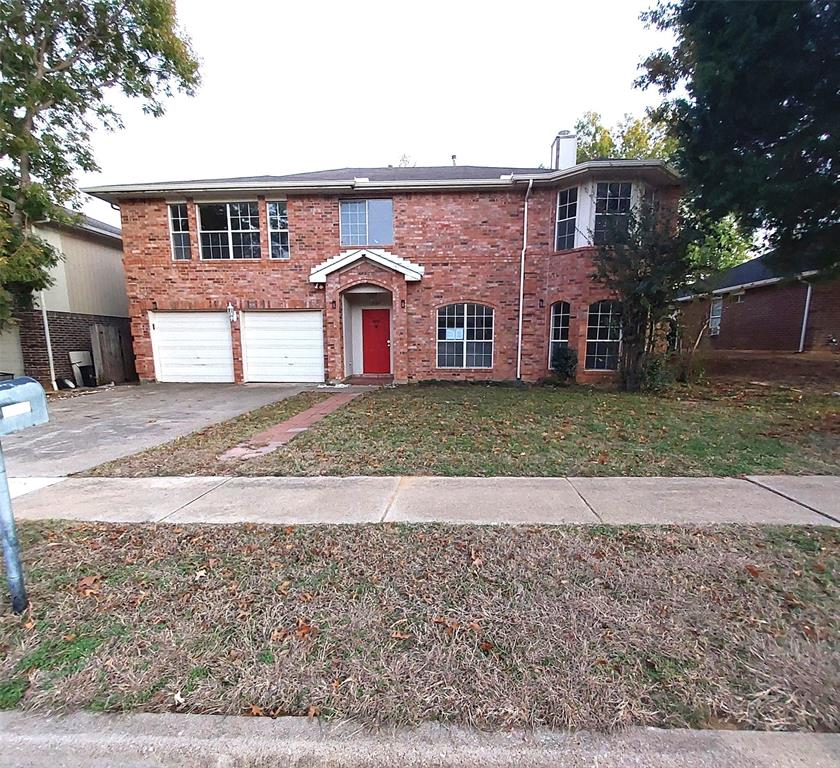 a front view of a house with a yard and a garage