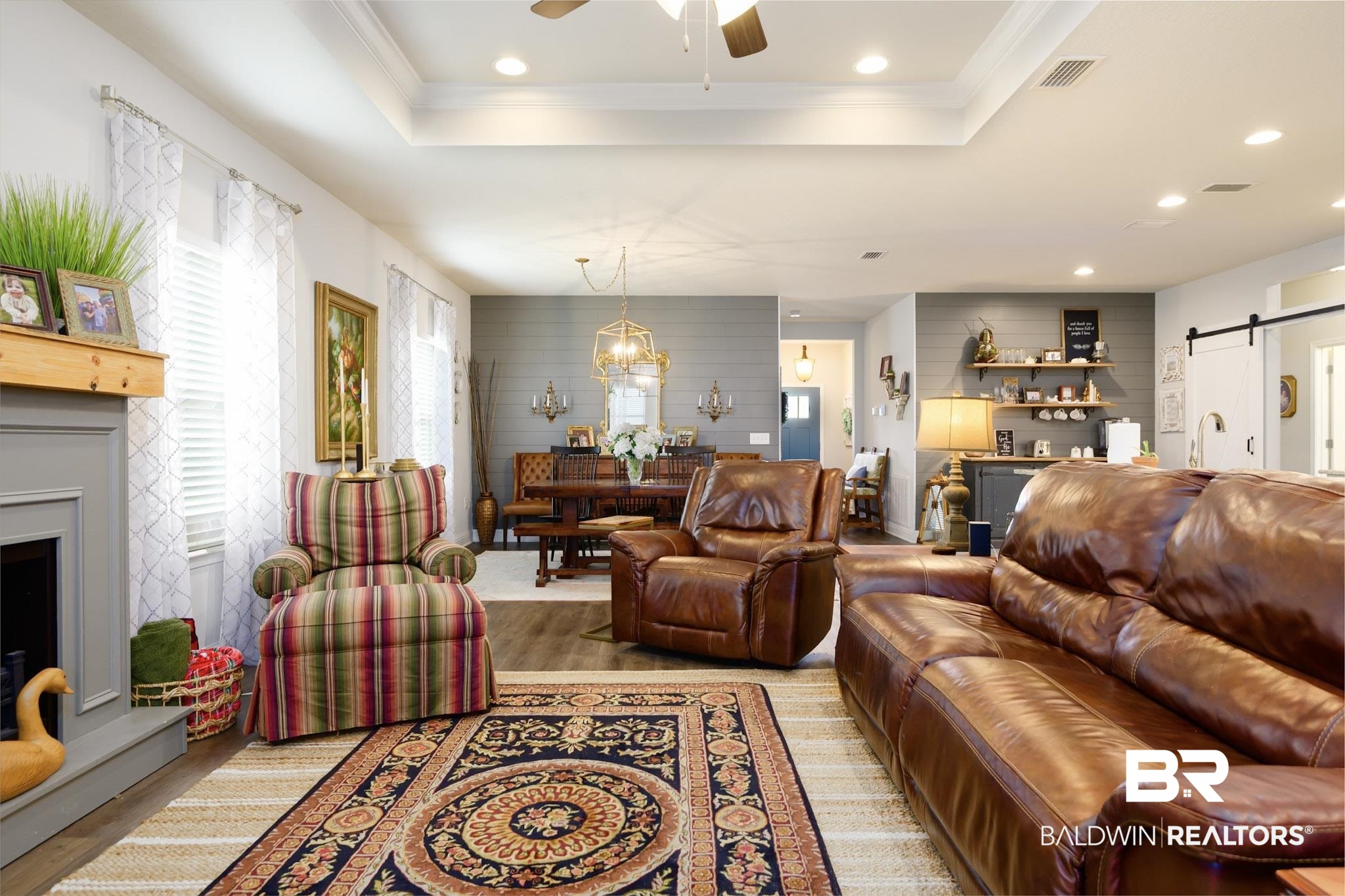 31751 Kestrel Loop Daphne, AL 36527 - Photo 6 of 21 Living room with a barn door, light wood finished floors, a raised ceiling, a fireplace with raised hearth, and ceiling fan