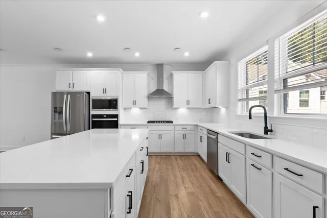 an empty room with wooden floor fireplace and windows