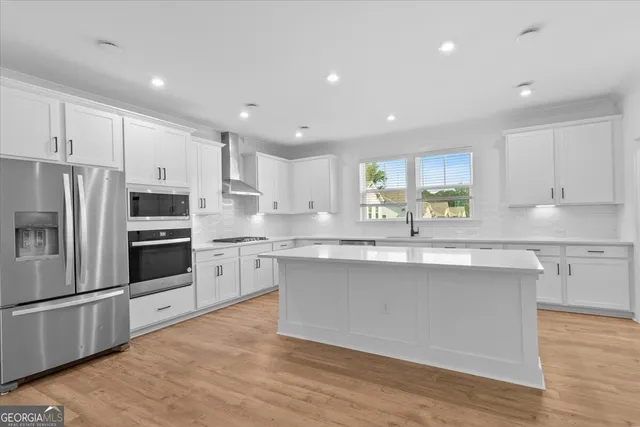 a kitchen with stainless steel appliances granite countertop a sink and cabinets