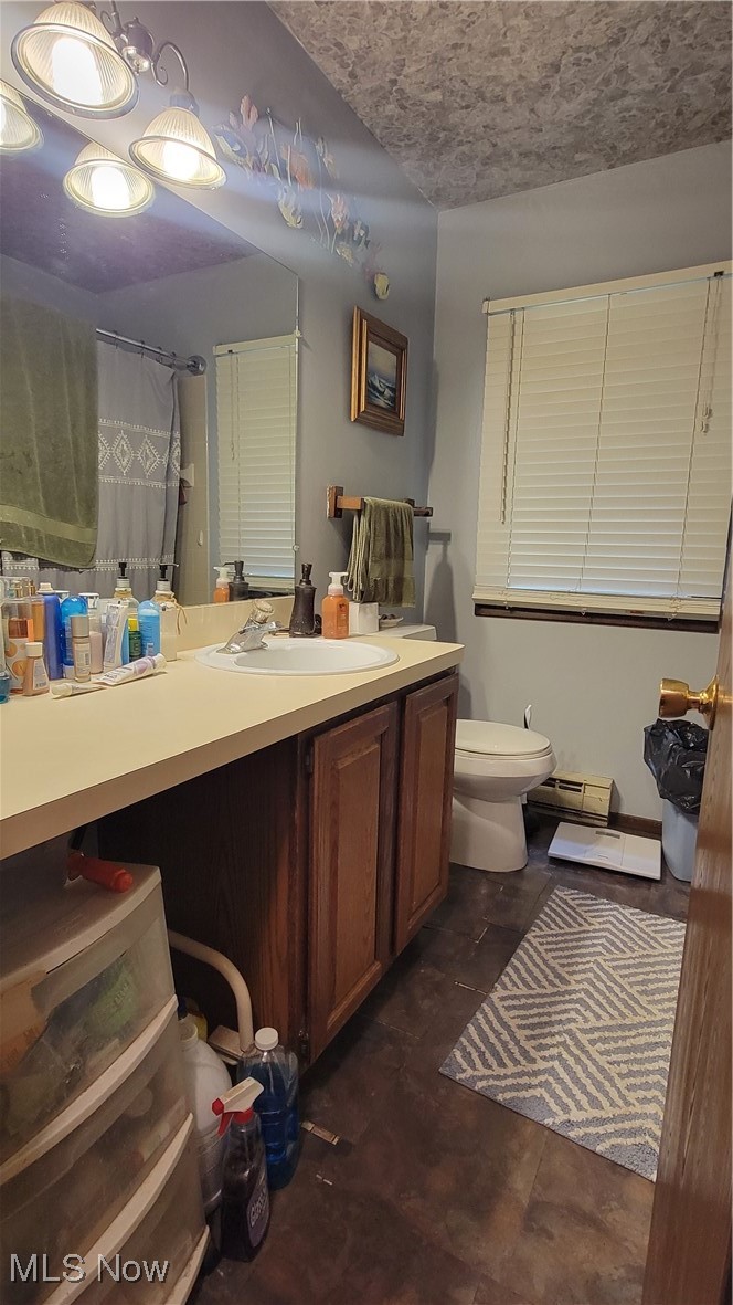 4133 Beat Road Litchfield, OH 44253 - Photo 23 of 25 Bathroom with vanity, a baseboard radiator, toilet, and a shower with shower curtain