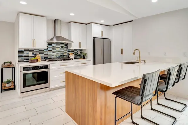 a kitchen with kitchen island a stove a sink and a refrigerator