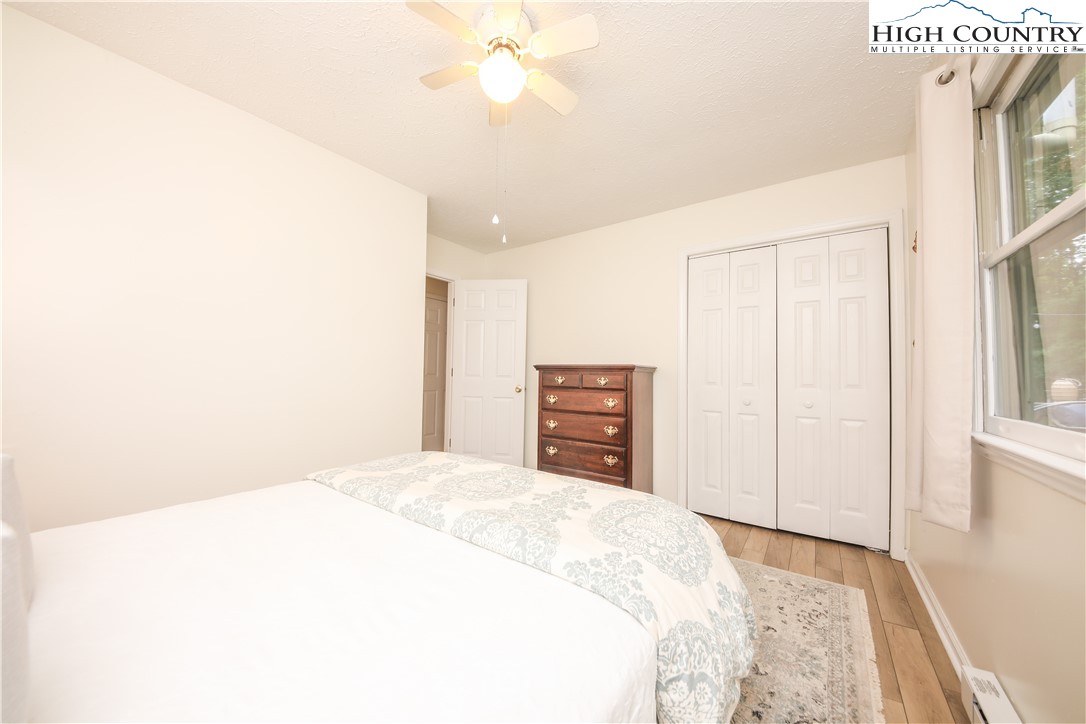 2171 Junaluska Road Boone, NC 28607 - Photo 7 of 46 a spacious bedroom with a bed and a chandelier