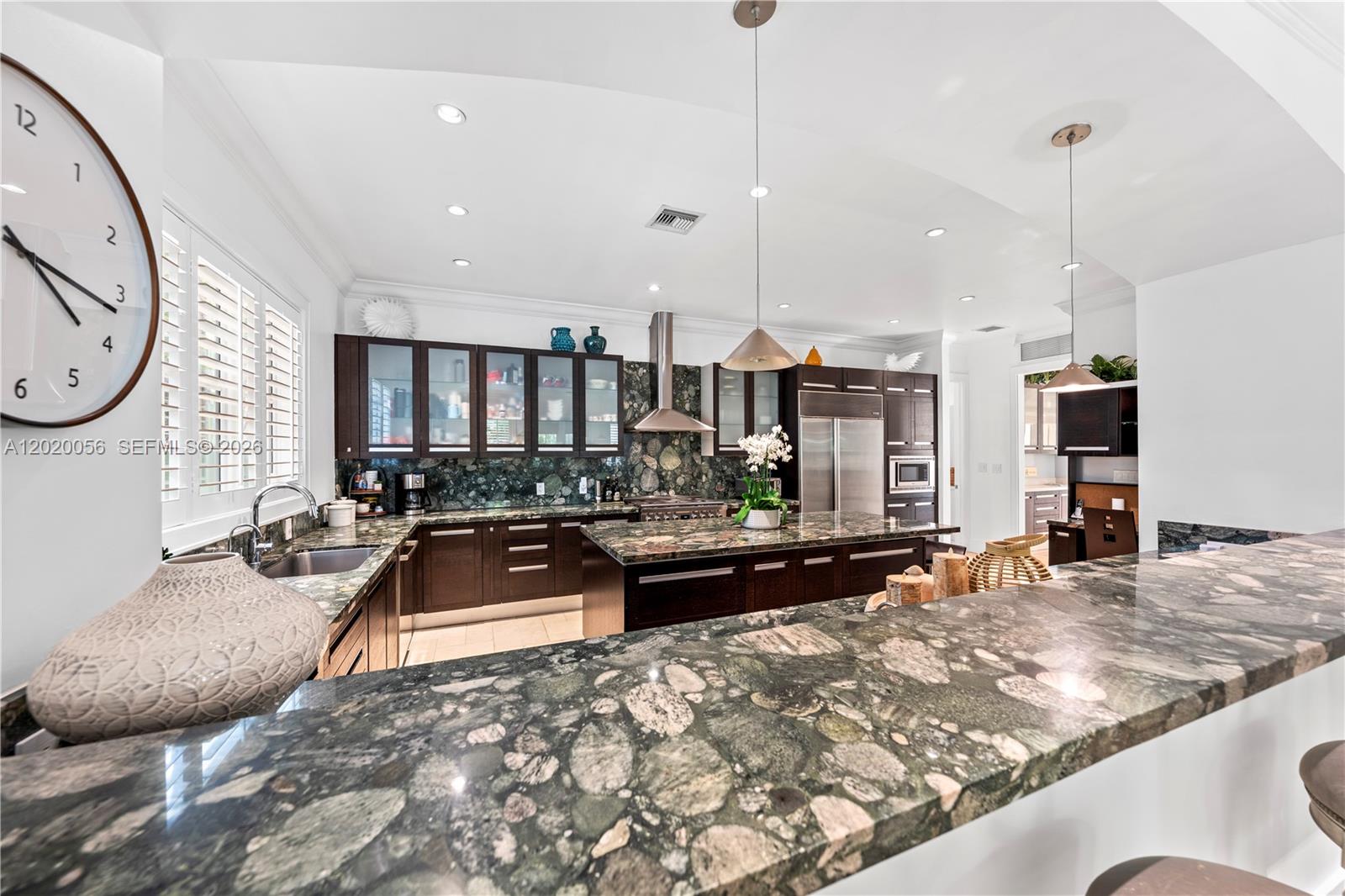 4196 Douglas Road Miami, FL 33133 - Photo 33 of 96 a large kitchen with kitchen island a large counter top space a sink stainless steel appliances and cabinets
