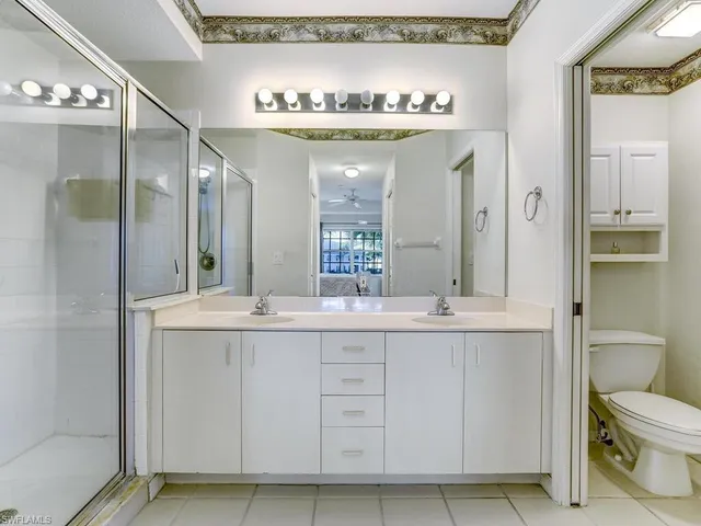 a bathroom with a granite countertop sink mirror vanity and toilet
