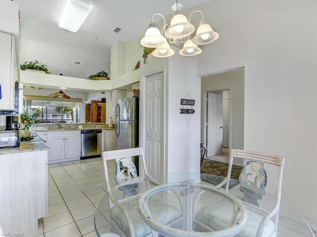 a kitchen with stainless steel appliances granite countertop a sink a stove and a chandelier