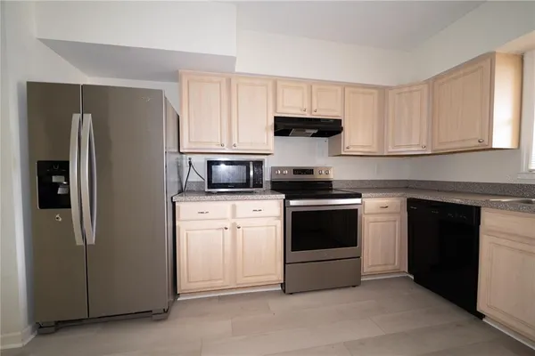 a kitchen with stainless steel appliances white cabinets and a refrigerator